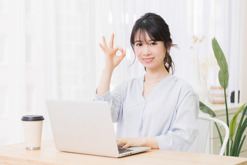 画像 正面を向いてオッケーというジェスチャーをしている若い女性